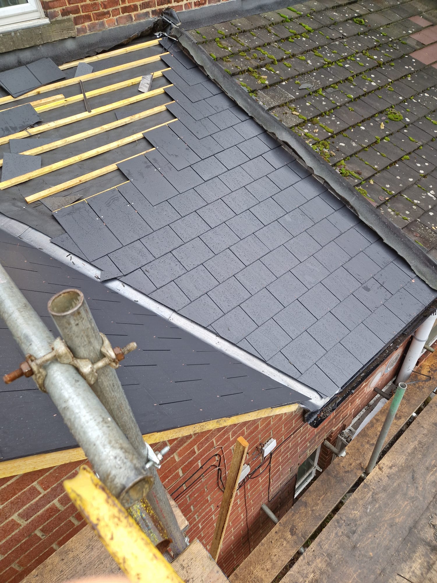 Roofers installing slate roof tiles